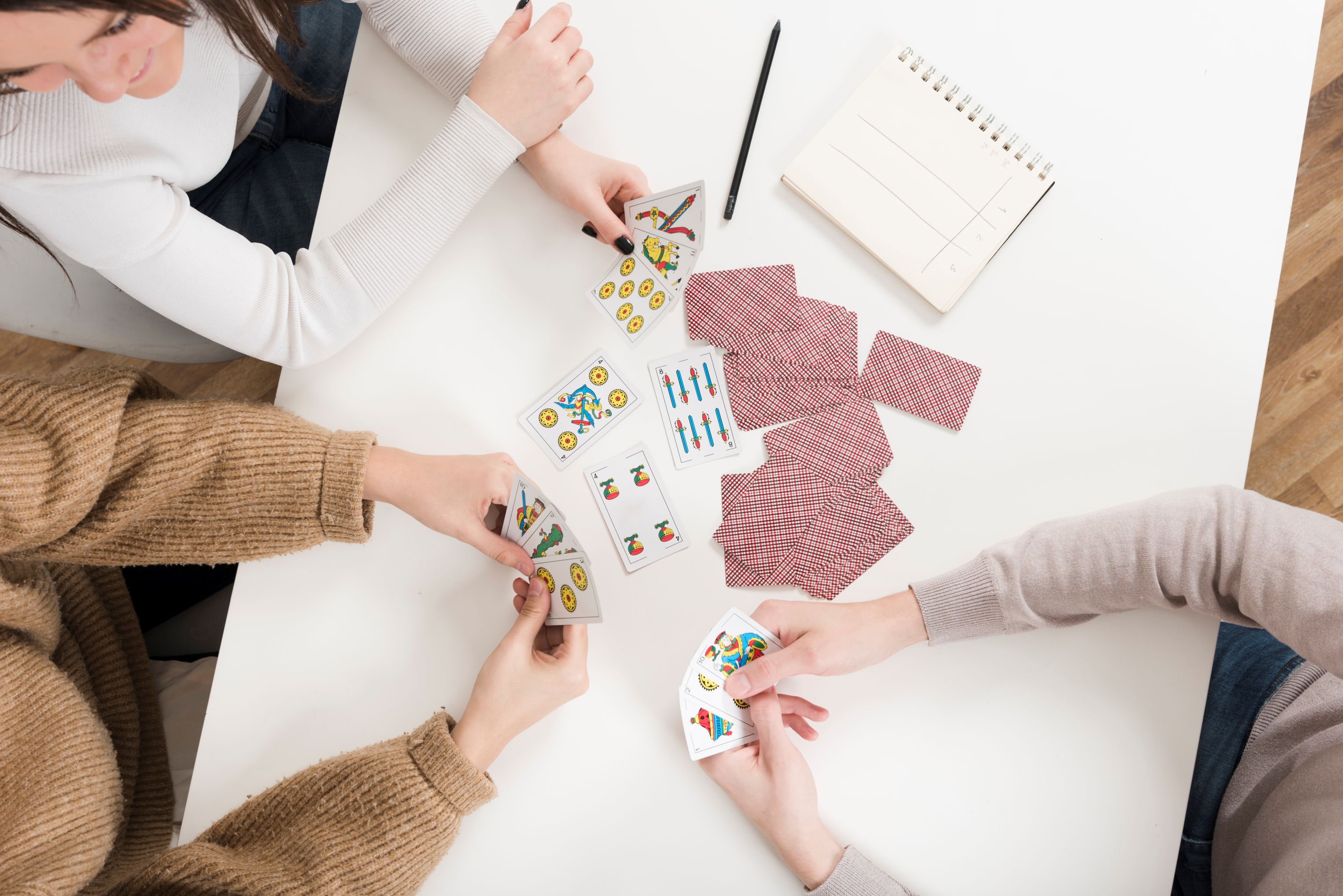 3 personnes qui jouent aux cartes