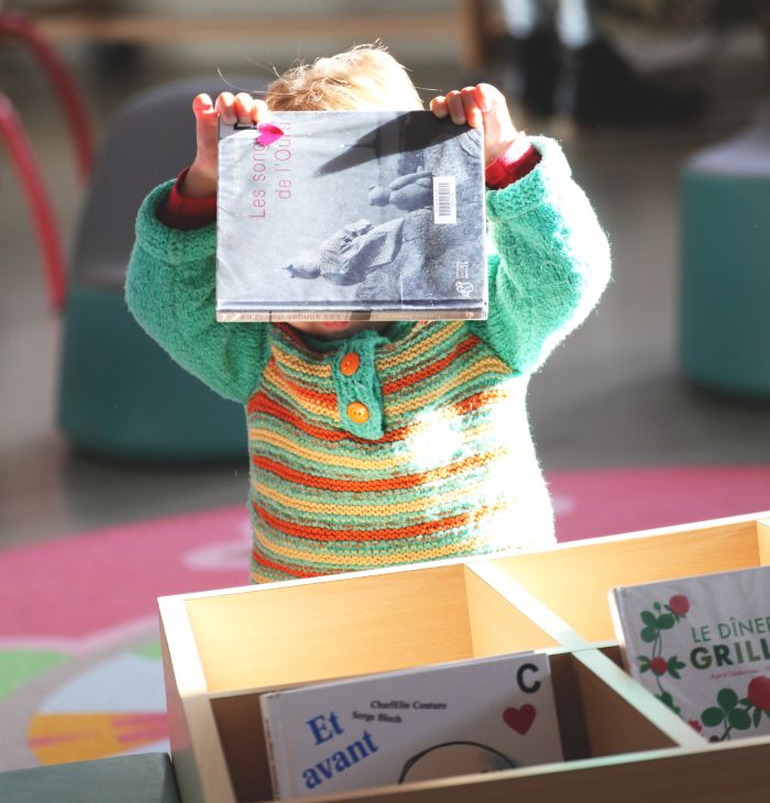 bébé se cachant le visage derrière un livre