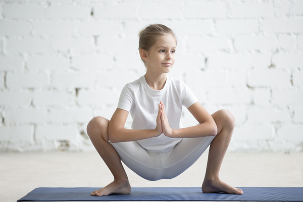 une enfant fait du yoga
