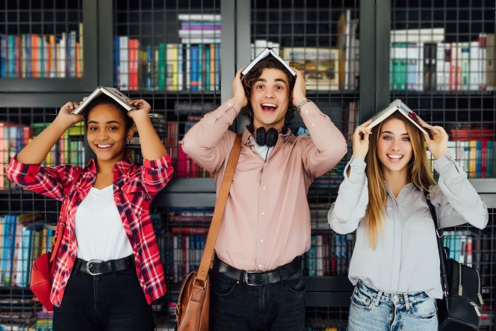 Ados souriants avec un livre sur la tête